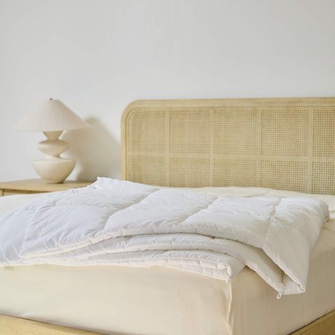 An Avec Goods Down Alternative Duvet Insert lying on the corner of a bed