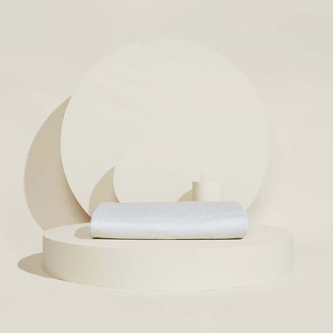 A folded Slumber Cloud Core Mattress Protector on a cream background
