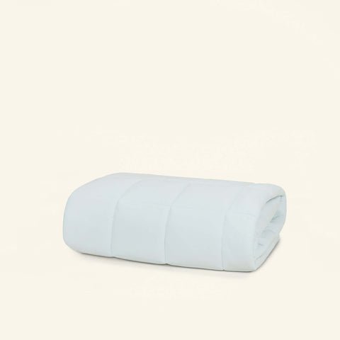 The Slumber Cloud Essential Mattress Pad made with Outlast temperature regulation technology, folded on a cream background