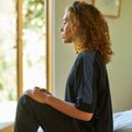 Woman wearing the Slumber Cloud Essential Raglan Pullover made with Outlast temperature regulation technology